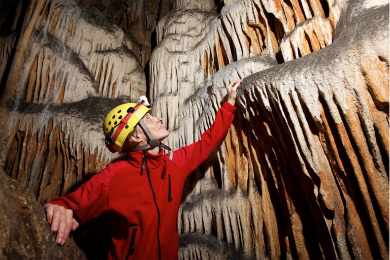 Woman exploring a cave with rock formations