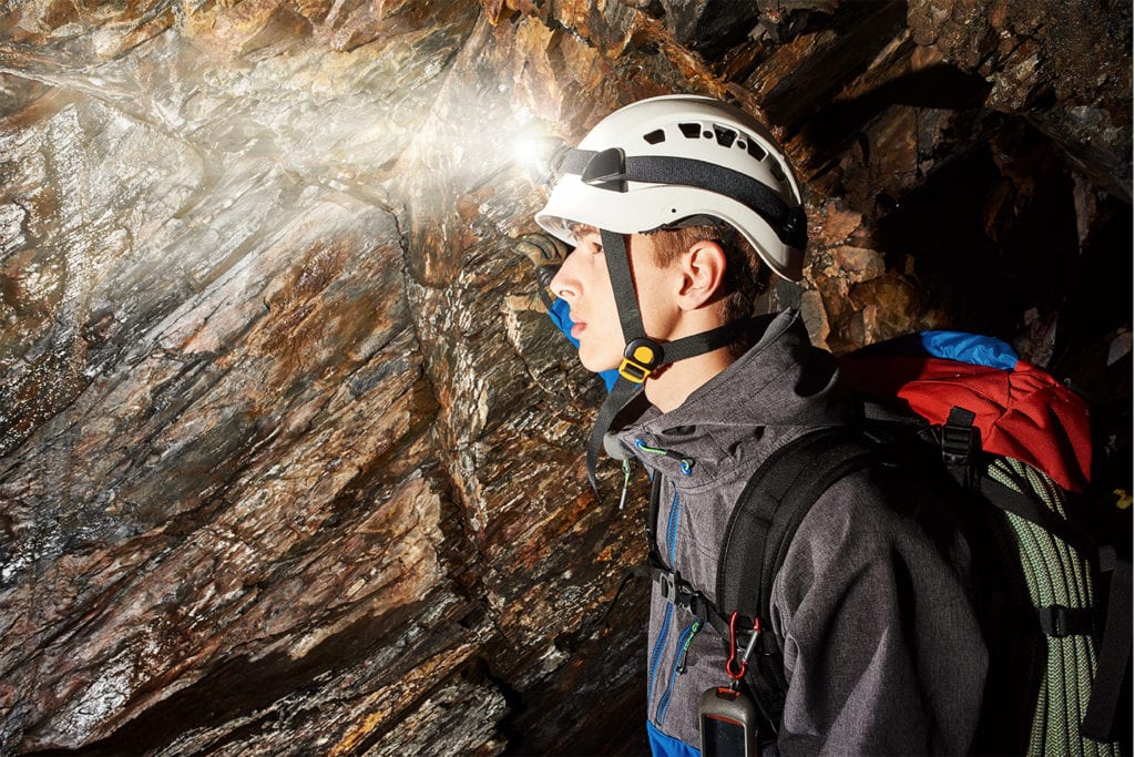 young man exploring a cave