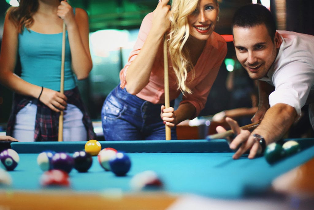 friends playing billiards together