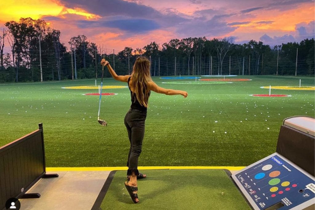 young woman hitting golf balls at Top Golf Chattanooga