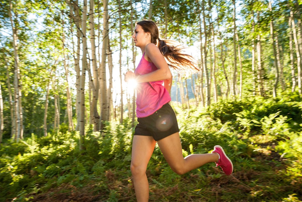 woman running on a wooded trail