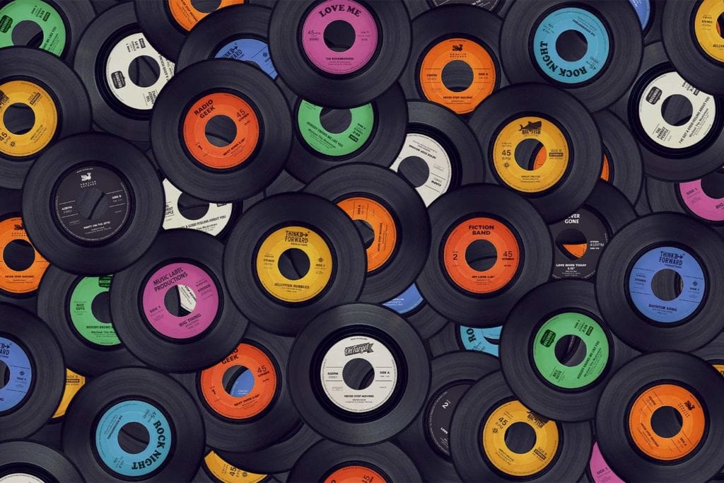 a pile of 45 inch vinyl records with colorful labels