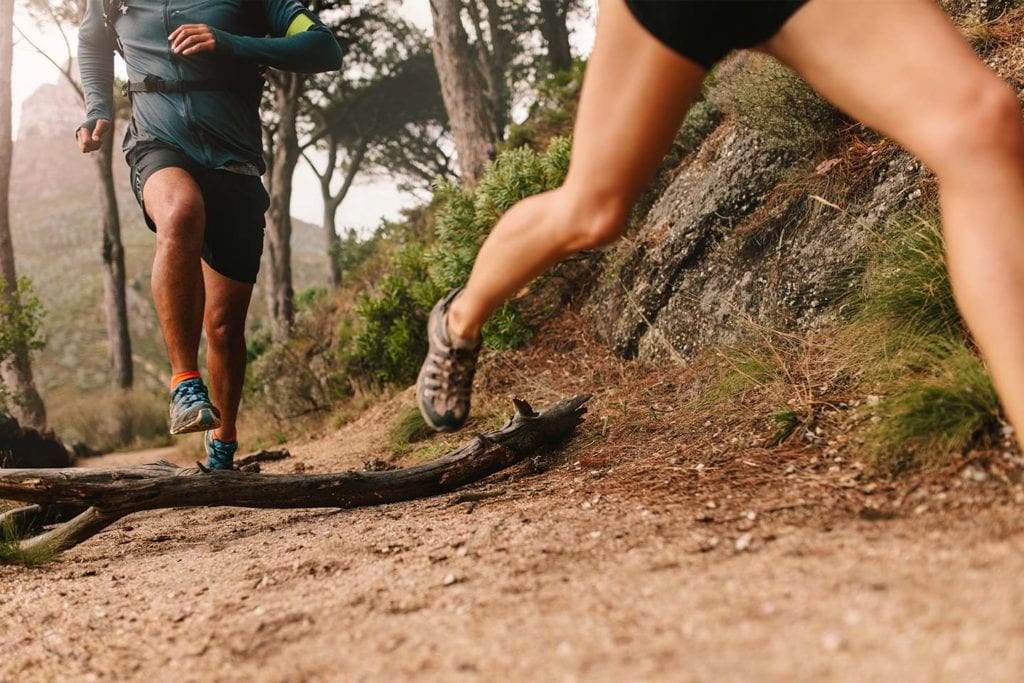 close up shot of people's legs as they are trail running