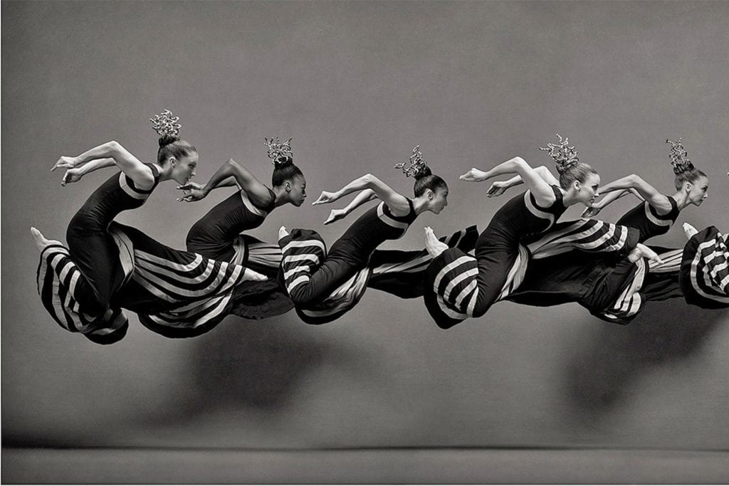 A dynamic black-and-white image of figures in motion, showcasing a fluid sequence of running poses with striped patterns.