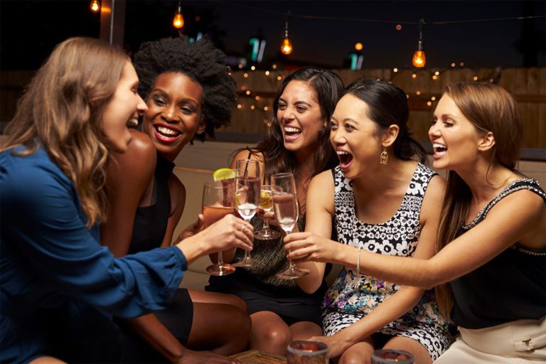 women drinking together at a bar
