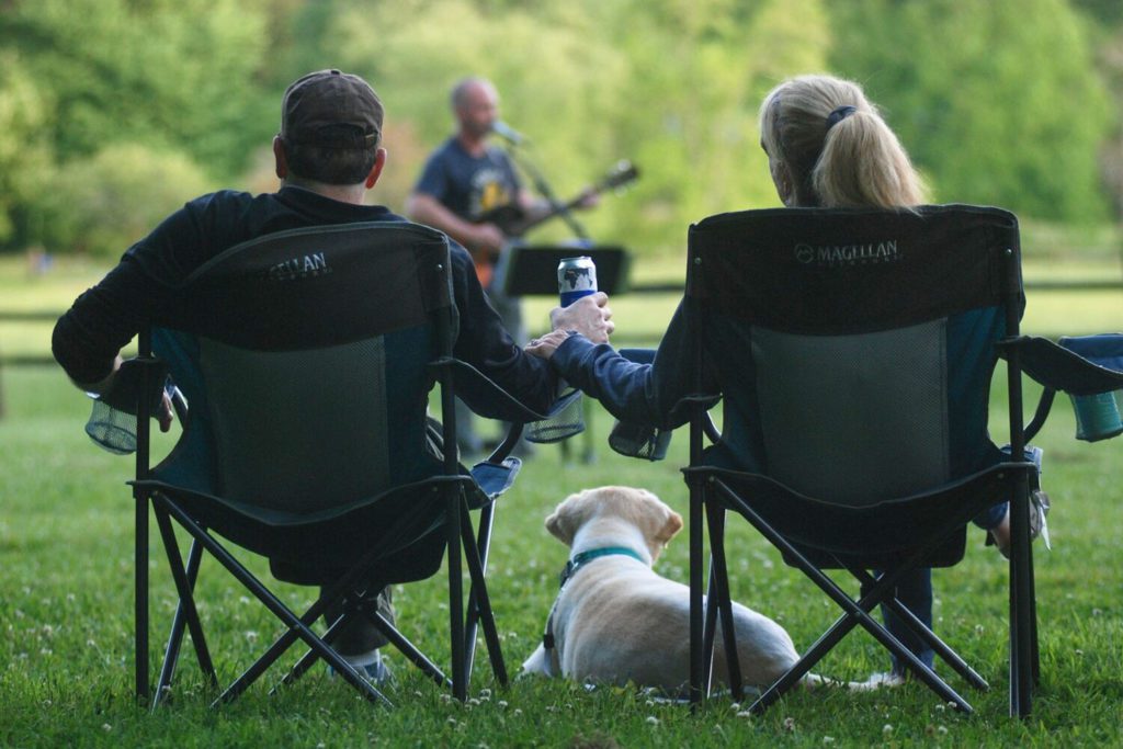 couple and their dog watching the Reflection Riding Summer Concert Series in Chattanooga