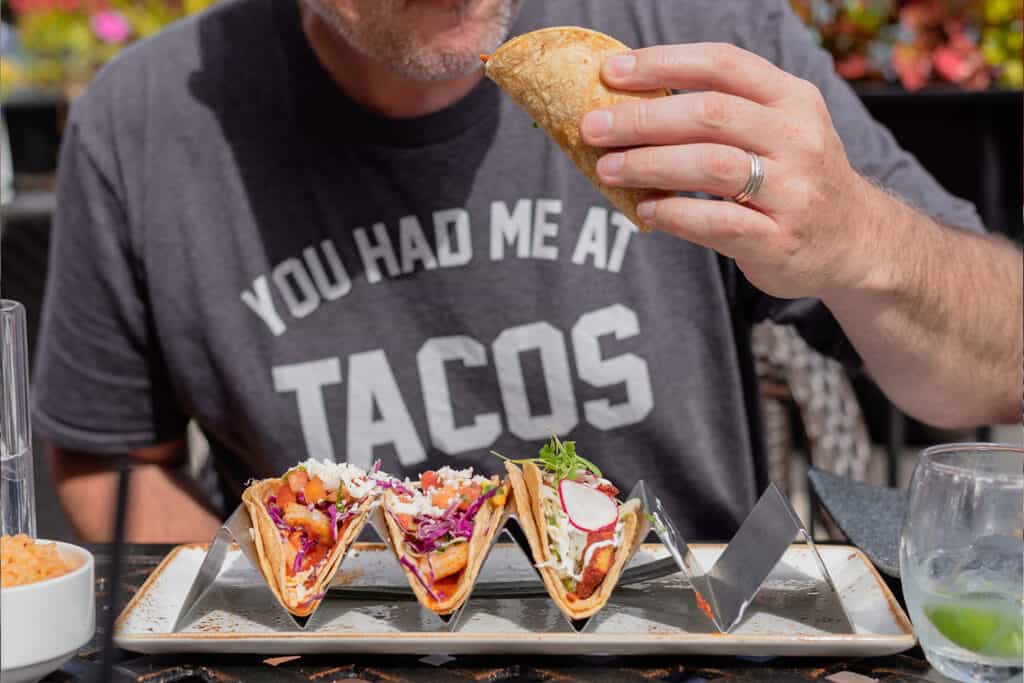 man eating at a taco bar