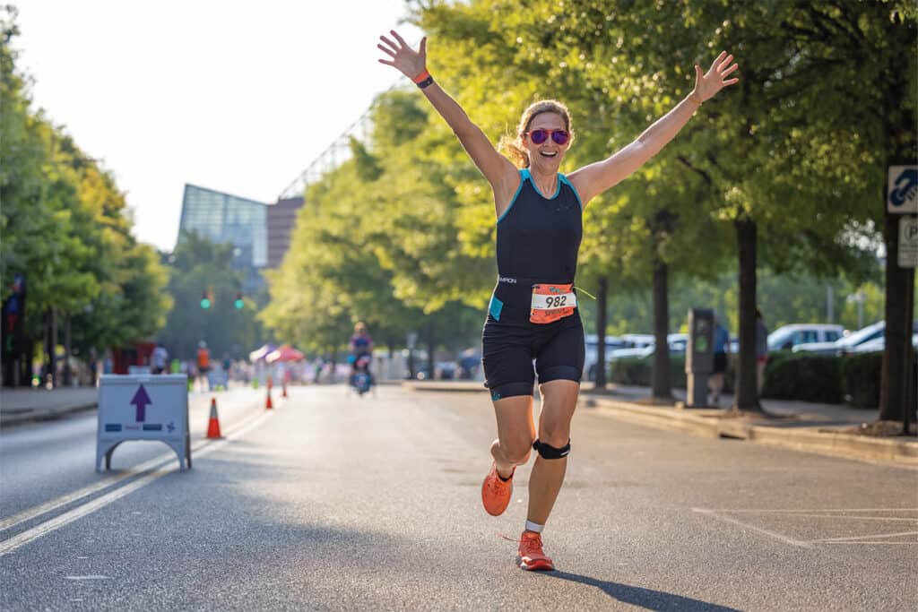 A girl running a race expressing joy