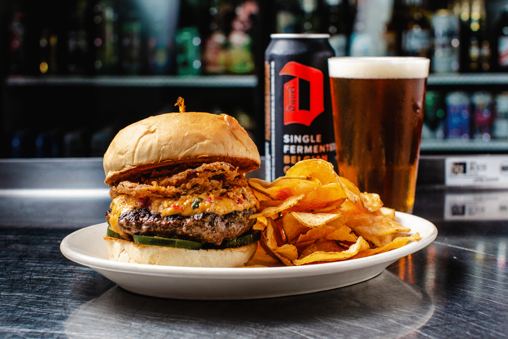 Burger chips and beer on table