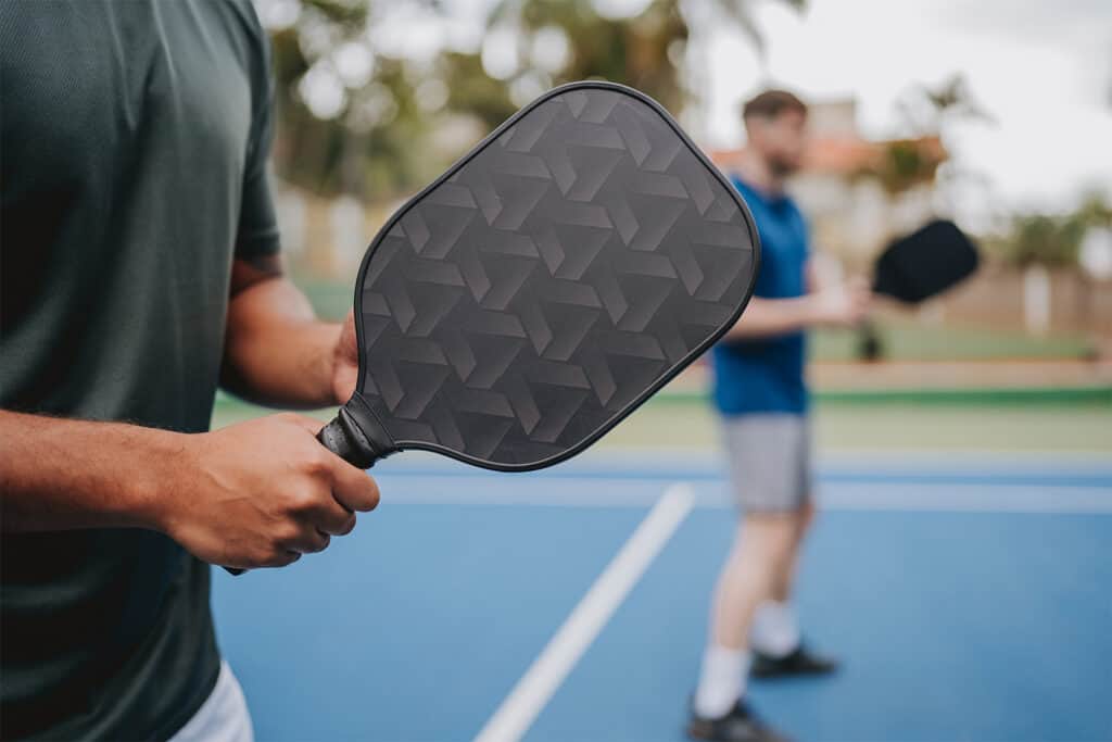 man holding pickleball paddle