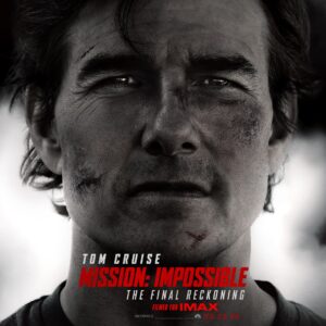 Close-up of a rugged man with scars, staring intensely; promotional poster for "Mission: Impossible - The Final Reckoning."