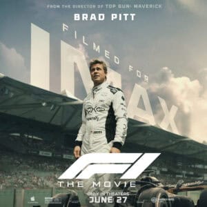 A confident race car driver in a sleek white suit stands in front of a racetrack, with the movie title and release date above.