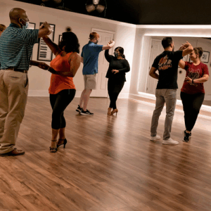 Couples dancing salsa in a dance room.