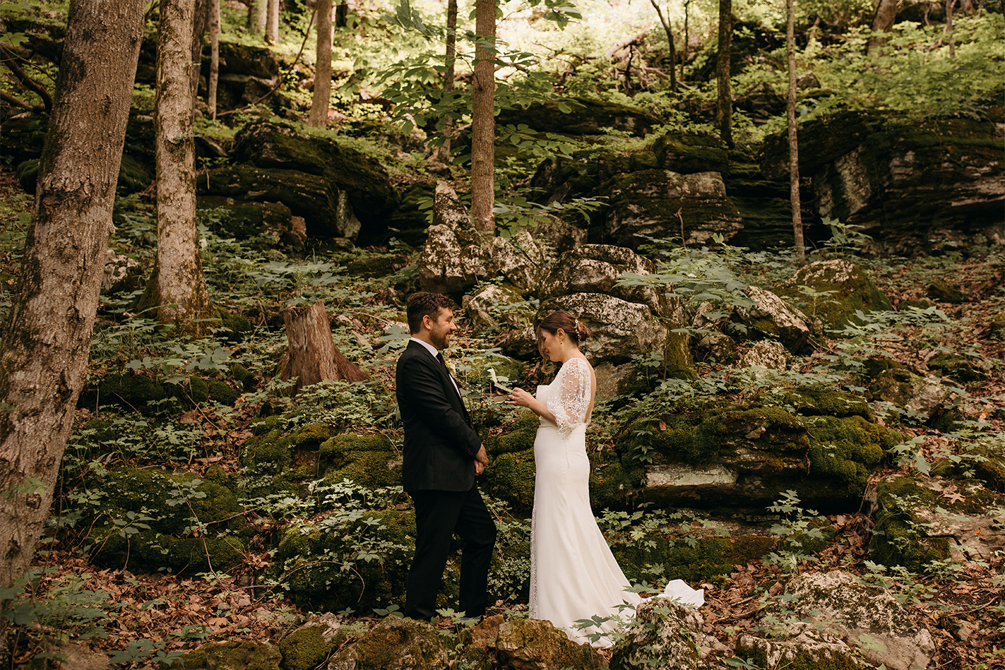 Bride and groom exchanging vows in forest